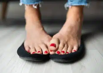 Close-up Of A Woman Sweaty Feet On Shoes On Hardwood Floor